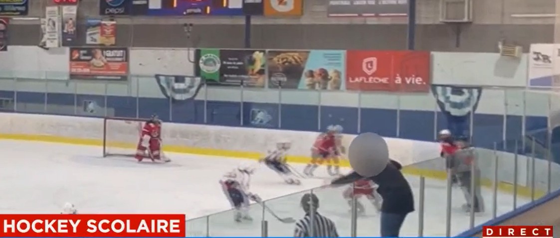 Une spectatrice grimpe une baie vitrée et tape la tête d'un officiel